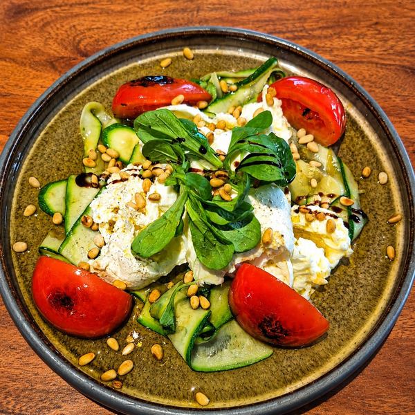 Burrata mit gegrillten Tomaten, Zucchinistreifen, Pinienkernen und Basilikum