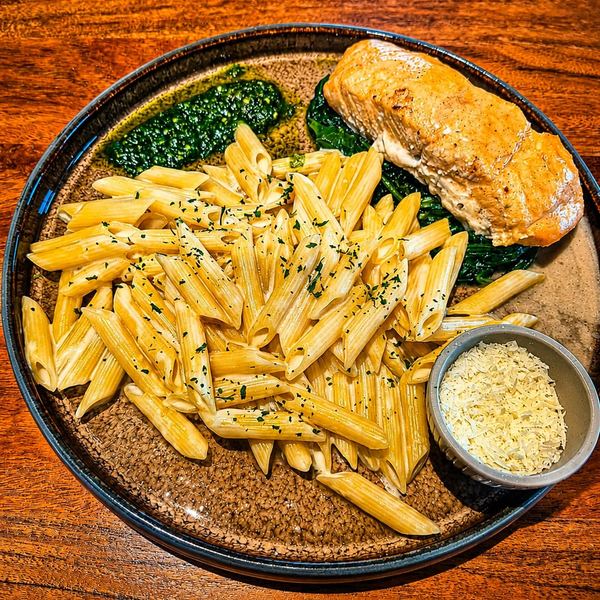 Penne mit Lachsfilet, Blattspinat, Pesto und geriebenem Parmesan