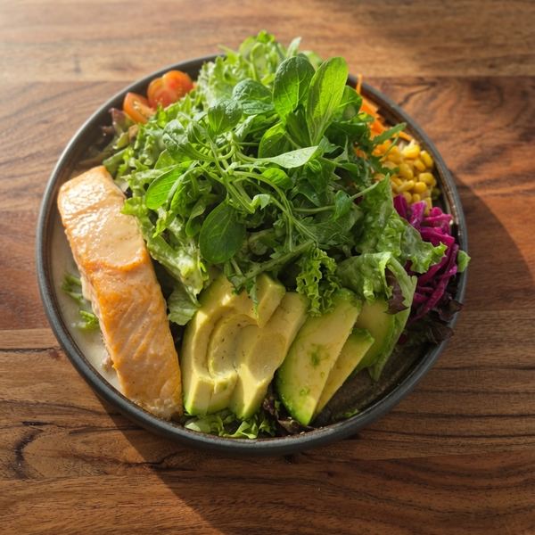 Großer Salat mit gebratenem Lachsfilet, Avocado, Mais, Rotkohl und Kirschtomaten